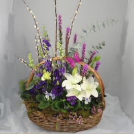 Basket arrangement with white lilies and purple flowers