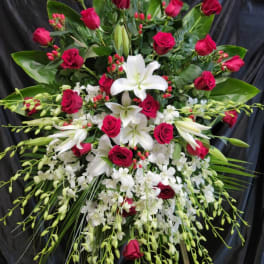 Large standing spray of red roses and white lilies on an easel