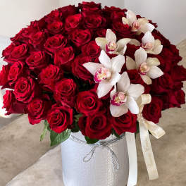 Red roses and white orchids arranged in a white hatbox