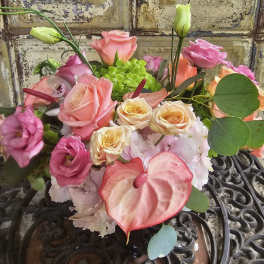 Mixed bouquet of pink and peach roses with an anthurium bloom