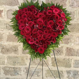 Heart-shaped red rose arrangement on a stand