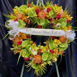 Heart-shaped floral wreath with a "We Love You Papa" ribbon