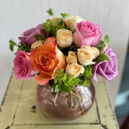 Mixed rose bouquet in a round glass vase