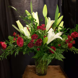 Red roses and white lilies in a clear glass vase