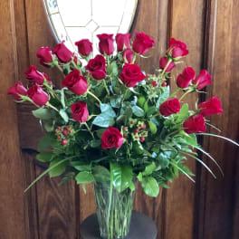 Red roses arranged in a clear glass vase