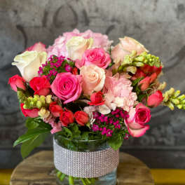 Bouquet of pink and white roses in a glass vase with a rhinestone wrap