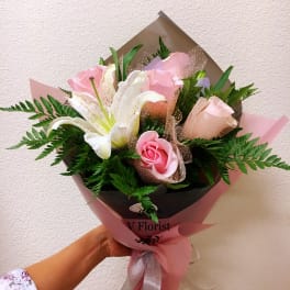 Pink roses and white lilies in pink and brown wrapping