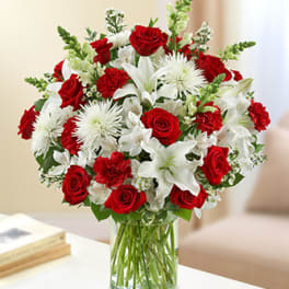 Red roses and white lilies in a clear glass vase