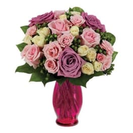 Pink and purple rose bouquet in a magenta glass vase