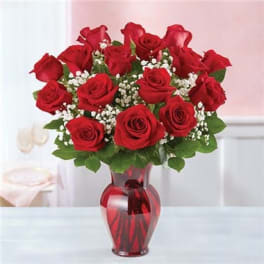 Red roses arranged in a red glass vase