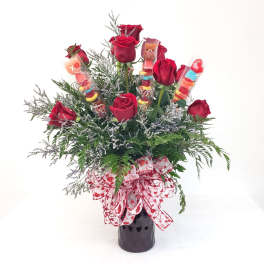 Red roses in a black vase with candy sticks and a heart ribbon