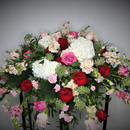Large arrangement of red, pink, and white flowers on a stand