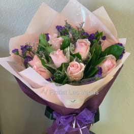 Bouquet of pink roses with purple filler flowers wrapped in pink and purple paper