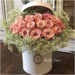 Pink roses arranged in a white hatbox with baby's breath
