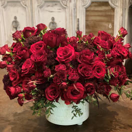 Large arrangement of red roses in a white container