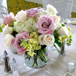 Pink and white rose centerpiece in a clear glass vase