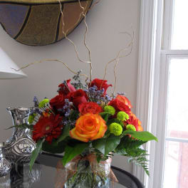 Bouquet of red and orange roses in a glass vase