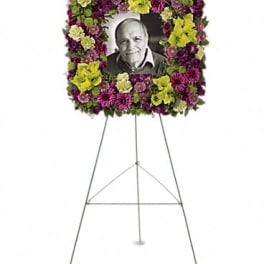 Floral standing wreath on an easel with a photo in the center