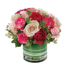 Bouquet of pink and cream roses in a striped glass vase