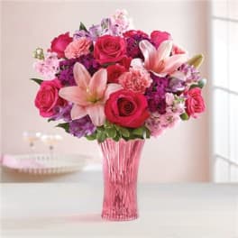Pink and purple bouquet with roses and lilies in a pink vase