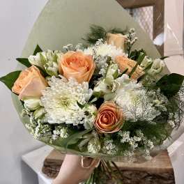 Peach roses and white chrysanthemums in a wrapped bouquet