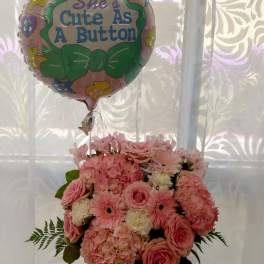 Pink flower bouquet with a "She's Cute As A Button" balloon