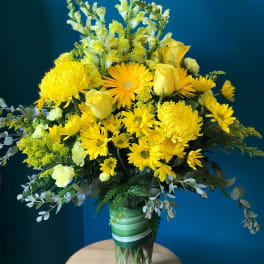 Yellow flowers arranged in a clear glass vase
