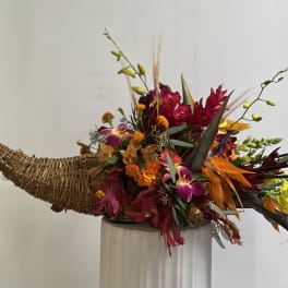 Tropical floral arrangement in a woven horn-shaped container