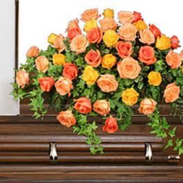 Orange and yellow roses arranged on a wooden casket