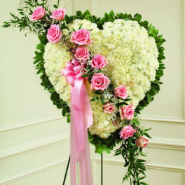 Heart-shaped floral spray with pink roses and a pink ribbon