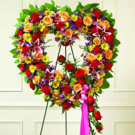 Heart-shaped floral wreath on an easel with roses and lilies