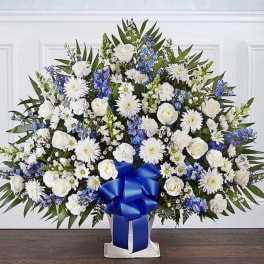 Large white and blue floral standing spray with a blue ribbon