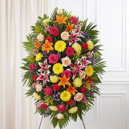 Large standing spray of mixed roses, lilies, and daisies on an easel
