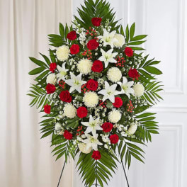 Standing floral spray with red roses, white lilies, and white pompons