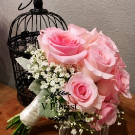 Pink rose bouquet with white filler flowers in a glass vase
