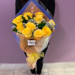 Bouquet of yellow roses wrapped in blue and clear paper