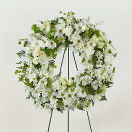 White floral wreath on a black stand