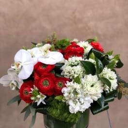 Red and white floral arrangement in a green vase