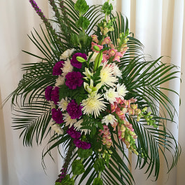 Tall floral spray with purple, white, and pink blooms and palm fronds