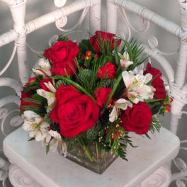 Red roses and white alstroemeria arranged in a square glass vase