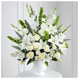 White lilies and roses arranged in a white vase