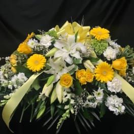 Yellow and white floral spray with lilies, roses, and daisies