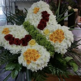 Large white floral arrangement with red, yellow, and orange roses