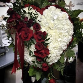 Heart-shaped floral tribute with white carnations and red roses