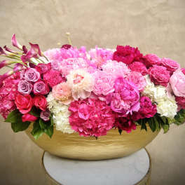 Pink and white floral arrangement in a gold bowl vase
