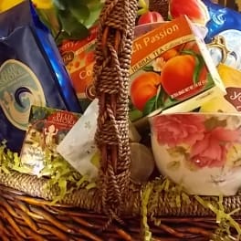 Gift basket with tea boxes and a floral teacup