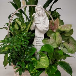 Basket of green houseplants with a white angel statue centerpiece