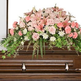 Pink floral casket spray with lilies, roses, and carnations