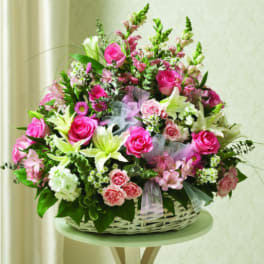 Pink and white flower arrangement in a white basket