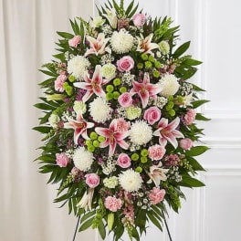 Standing floral spray with pink roses, lilies, and white mums on an easel
